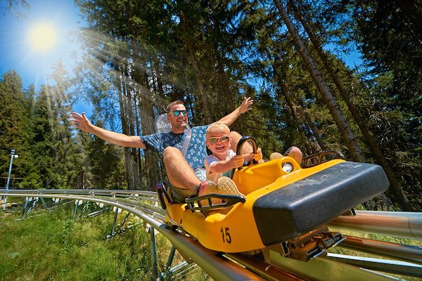 Père avec son enfant dans la luge sur rail des 7 Laux